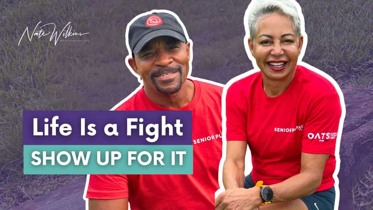Shebah and Nate Wilkins smiling in activewear with text overlay “Life Is a Fight – Show Up For It,” representing empowered aging and functional fitness.